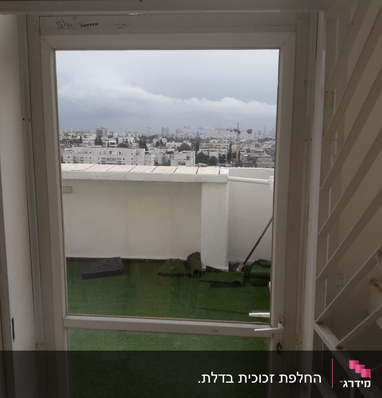 דלת זכוכית עם נוף לעיר ברקע